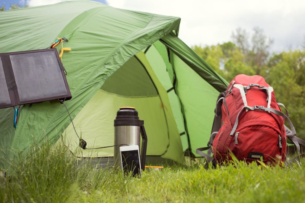 Ausrüstungsgegenstände neben dem Zelt, bereit für den Camping-Einsatz.