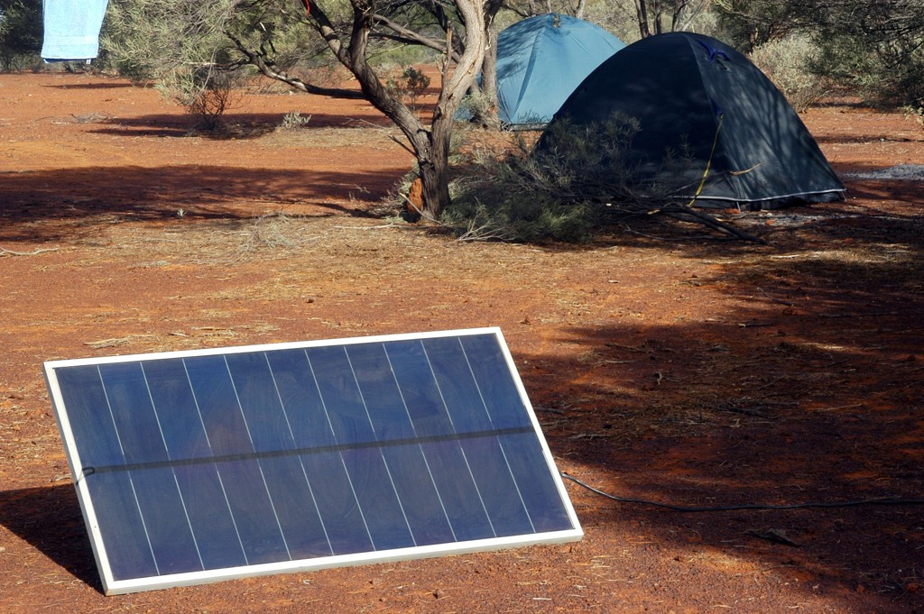 Solarpanel neben einem Campingzelt in einem Waldgebiet, perfekt für mobile Energie.