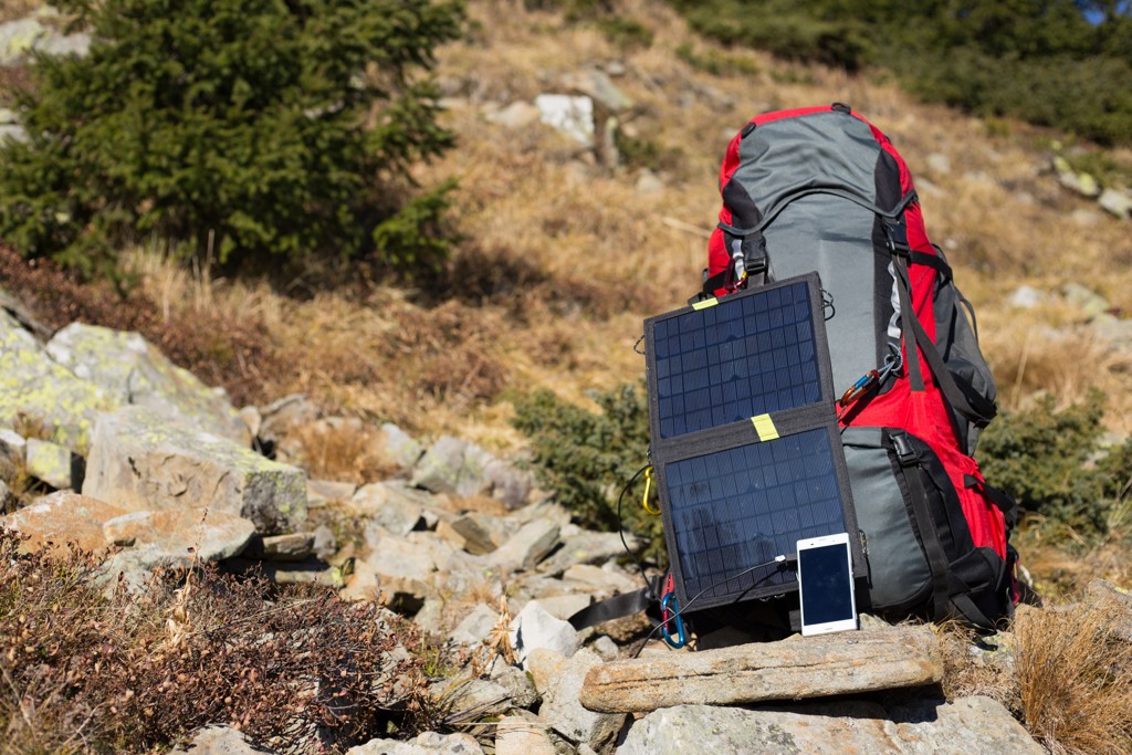 Kompaktes Solarpanel, das an einem großen Wanderrucksack angebracht ist, für effiziente Energieversorgung unterwegs.