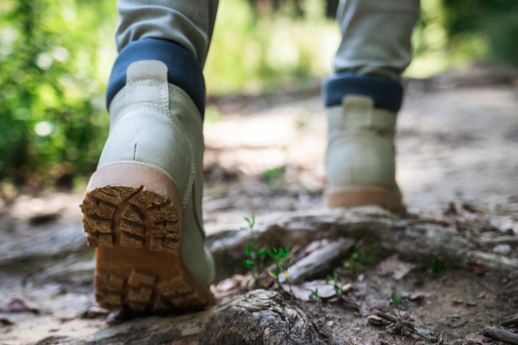 Nahaufnahme von PFC-freien Schuhen beim Wandern durch den Wald.