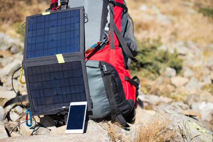 Solarenergie: Großes Solarpanel auf einem Campingplatz in der Wüste, versorgt Zelte mit nachhaltiger Energie.