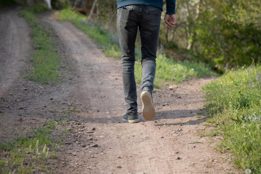 Detailaufnahme von Schuhen beim Laufen auf einem Waldweg.